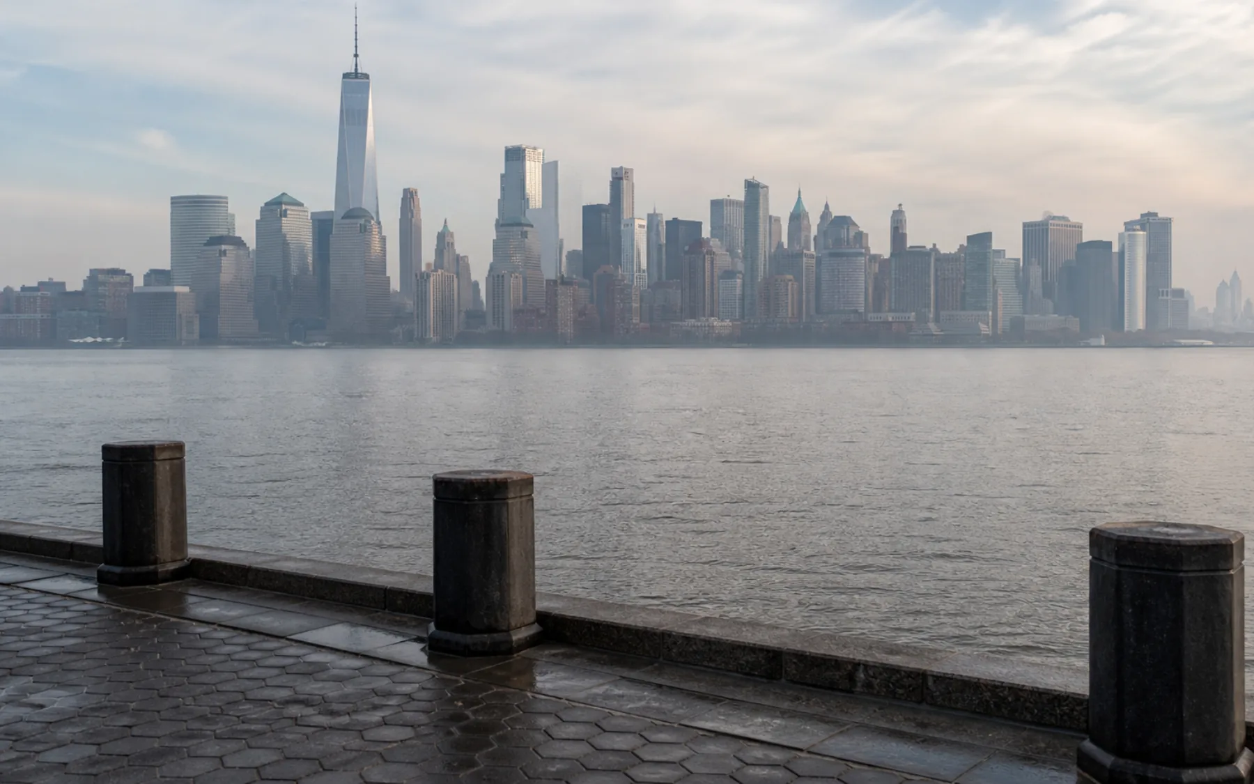 Lower Manhattan emerging through pale morning haze across the water